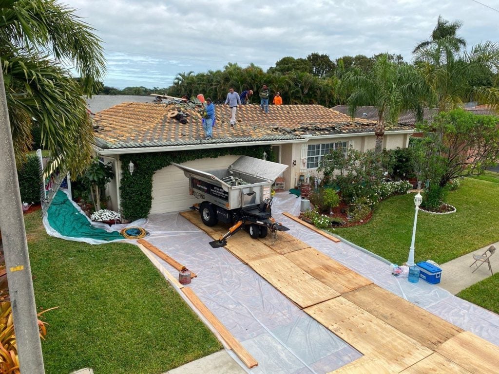 Equipter roofing debris removal equipment protecting driveways and pavers during tile roof replacement in South Florida