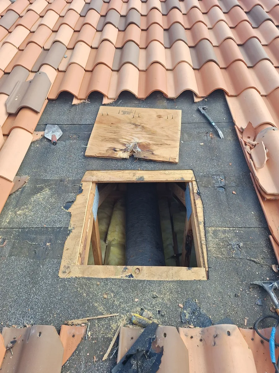 Rotted plywood decking cut out and removed at a gooseneck vent on a clay tile roof in West Palm Beach